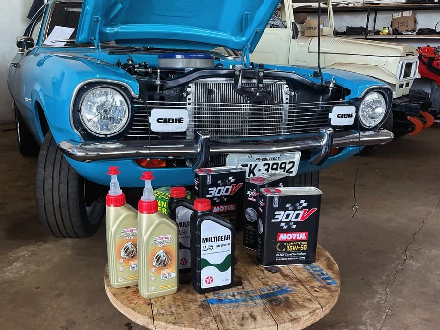 Ford Maverick com o capô aberto e óleos preparados para a revisão